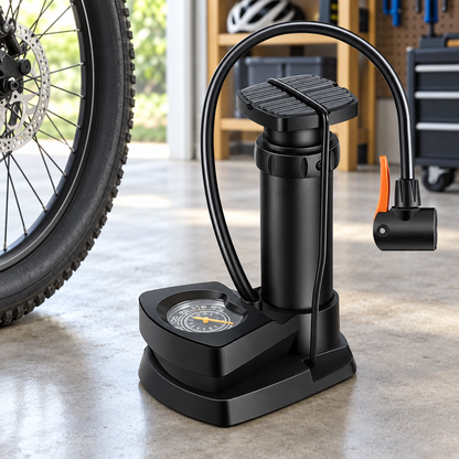 Compact foot air pump beside a bicycle wheel