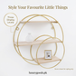 Golden round wall shelf styled with small decorative accents